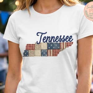 May include: White t-shirt featuring the state of Tennessee in a patchwork design. The word "Tennessee" is embroidered in blue script above the state outline, which incorporates red, white, and blue patterns.