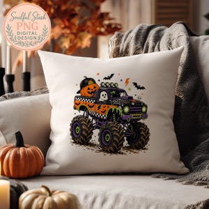 A pillow with a Halloween-themed graphic of a monster truck, featuring a jack-o-lantern and bats, is displayed on a couch.