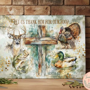 May include: A canvas print with a watercolour illustration of a deer, fish, turkey, and duck. A wooden cross is in the centre, with the text "LET US THANK HIM FOR OUR FOOD" and "GENESIS 9:3". The artwork has a rustic, outdoorsy theme.