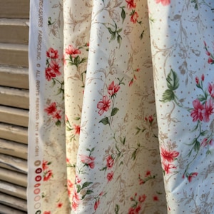 May include: Cream-colored fabric with a floral pattern featuring red flowers, green leaves, and brown stems. The fabric has a dotted background and the text "TIMELESS TREASURES FABRICS, INC. ALL RIGHTS RESERVED. PATT # HW-C8815" is visible.