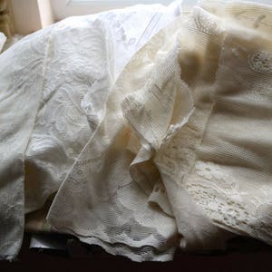 May include: A pile of white lace fabric with different patterns and textures.