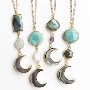 Peut inclure: Trois colliers en or avec différents pendentifs en pierres précieuses et des breloques en forme de croissant de lune. Les pendentifs comprennent une pierre verte en forme de larme, une pierre verte carrée et une pierre verte ronde. Les colliers sont sur un fond blanc.