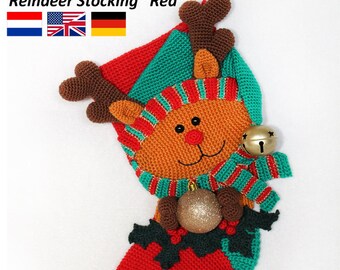 May include: Crocheted reindeer stocking with a red, green, and brown color scheme. The stocking has a bell, a gold ornament, and holly leaves. The text "Reindeer Stocking "Red"" is visible at the top of the image.