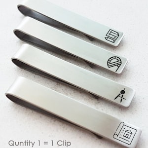 May include: Four silver tie clips with different architectural designs engraved on them. The designs include a protractor, a compass, a ruler and a house plan. The text "Quantity 1 = 1 Clip" is printed below the tie clips.