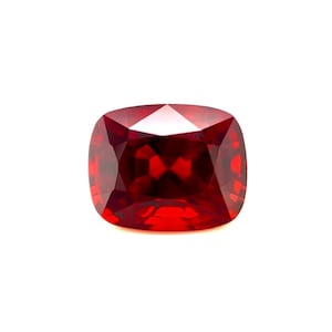 Puede incluir: Una piedra preciosa de talla cojín de color rojo intenso con un alto pulido.