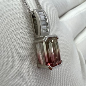 以下が含まれることがあります： ピンクとグリーンのグラデーションの大きな長方形のバイカラーの宝石がついたシルバーのペンダントネックレス。ペンダントは、小さなバゲット型のダイヤモンドがセットされています。