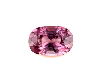 May include: A faceted, oval-cut gemstone with a gradient of pink hues. The gem transitions from a deep magenta at the edges to a lighter, more translucent pink in the center. The stone is set against a white background.