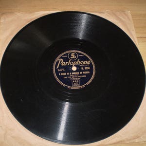 Könnte beinhalten: Eine schwarze Schallplatte mit einem Etikett, auf dem "Parlophone R. 3258 A Rose in a Garden of Weeds The Five Smith Brothers Box and Cox" steht.