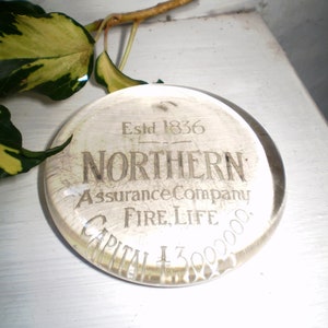 May include: A clear glass paperweight with the text "Estd 1836 NORTHERN Assurance Company FIRE, LIFE CAPITAL £300,000" etched into the surface.