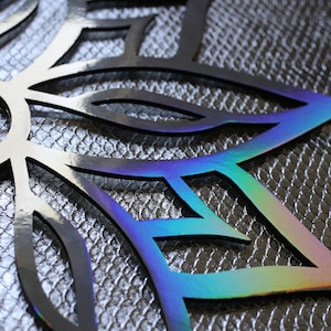Könnte beinhalten: Dekorativer, lasergeschnittener Metallschneeflocke mit schwarzem Finish und schillernden Kanten. Die Schneeflocke hat ein detailliertes, offenes Design mit silbernem Hintergrund. Die Kanten reflektieren einen Regenbogen an Farben.