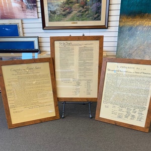May include: Three framed documents, each with a different historical text. The top document reads "We the People", the middle document reads "Congress of the United States", and the bottom document reads "In Congress, July 4, 1776".
