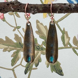 a pair of earrings hanging from a tree branch