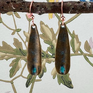 a pair of earrings sitting on top of a tree branch