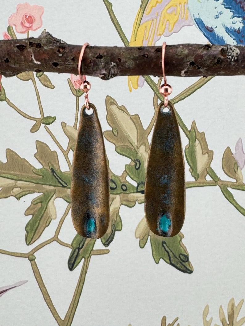 a pair of earrings sitting on top of a tree branch