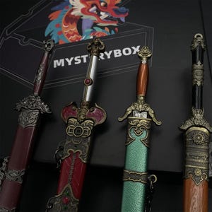 May include: Four decorative swords with detailed handles and sheaths. The swords display a range of colours, including red, silver, brown, and green. The blades are not visible. The swords are positioned in front of a box with the text "MYSTERYBOX".