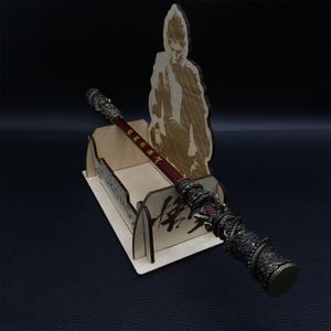 May include: A wooden stand with a carved image of a monkey holding a staff. The staff is made of metal and has a red and black design. The stand has the word "Sun Wukong" written on it in Chinese characters.