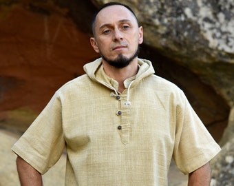 May include: A beige short-sleeved shirt with a button-up collar and a hood. The shirt has a relaxed fit and is made of a lightweight fabric.