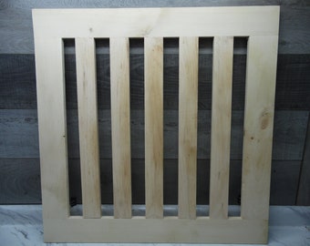 May include: A plain wooden gate with seven vertical slats. The gate is unfinished and ready to be painted or stained.