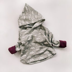 Puede incluir: Sudadera gris con capucha con estampado de nubes y puños burdeos.