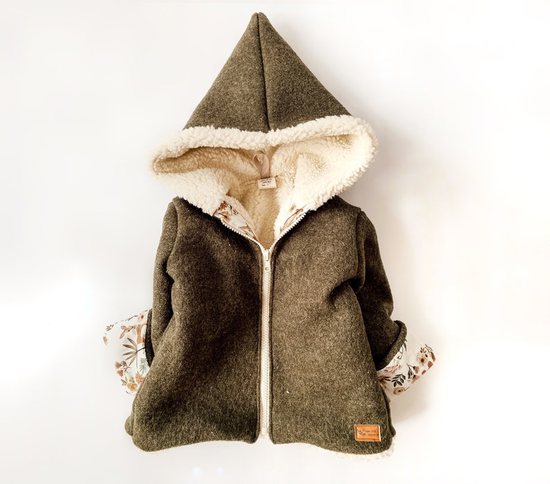 May include: A green hooded jacket with a white sherpa lining and floral print lining. The jacket has a zipper closure and a brown leather label.
