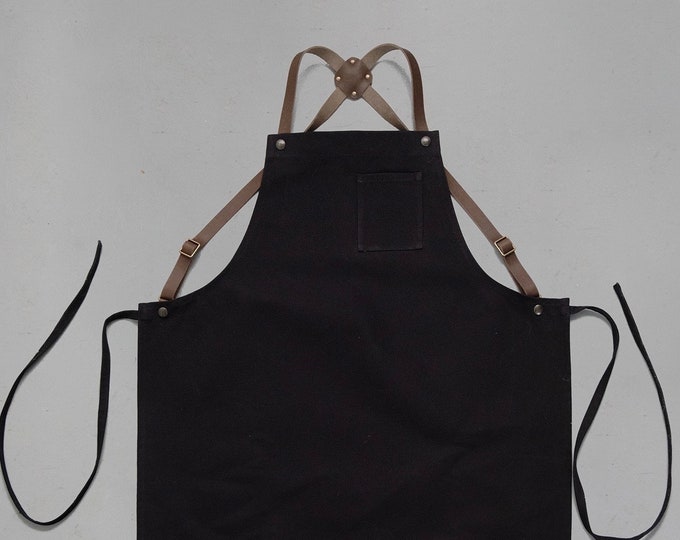 Apron with leather straps crossed at the back