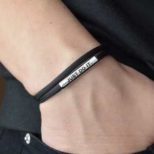 May include: Black bracelet with a silver bar that reads "JUST DO IT."