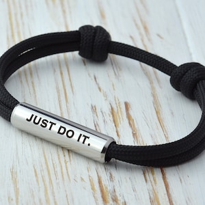 May include: Black paracord bracelet with a silver metal bar that says "JUST DO IT."