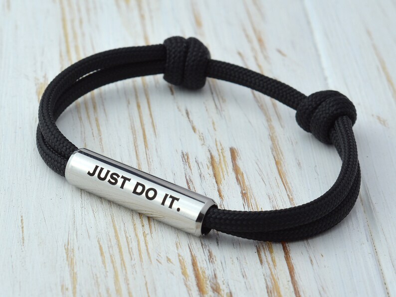 May include: Black paracord bracelet with a silver metal bar that says "JUST DO IT."
