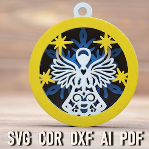 May include: A laser-cut wooden ornament featuring a white angel with wings, a heart, and a snowflake design. The ornament is yellow with a blue and black snowflake design inside. The text "SVG CDR DXF AI PDF" is printed below the ornament.