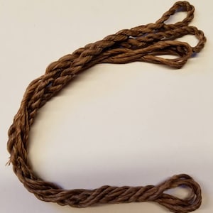 May include: A brown braided rope with a loop at each end.