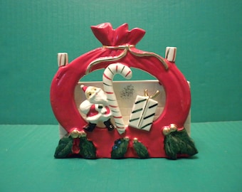 Ucagco Santa with a Candy Cane and Presents in Front of Red santa Bag Silhouette Tied with a Gold Ribbon - Holly Trimmed - Candy Cane Holder