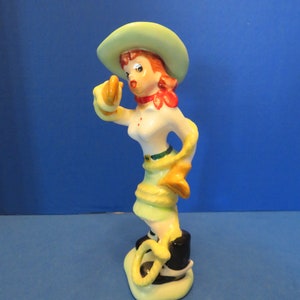 Napco Cowgirl All Tangled Up in Her Lasso! She Wears a Green Cowboy Hat, Black Boots w White Buckles, Green Fringe Skirt. She is a Hot Mess!