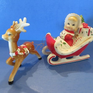 Rena japonesa vintage com arreios de bengala de doces puxando uma linda garota fazendo compras de Natal em um trenó carregado com presentes e árvore de Natal - Excelente!