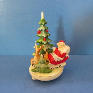 頼れるトナカイに引かれたソリに乗った日本のヴィンテージサンタ - 巨大なクリスマスツリーの前を通り過ぎる - 素晴らしいが入手困難