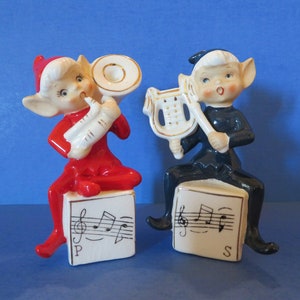 Set di due saliere e pepiere Napco Pixie: ciascuna raffigura un corno o un&#39;arpa seduti su una base con note musicali. Un meraviglioso oggetto vintage!
