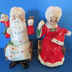 Norcrest, o Papai Noel carrega seu elfo no ombro e a Mamãe Noel fuma seu cachimbo enquanto a Mamãe Noel remenda seu gorro de Papai Noel!