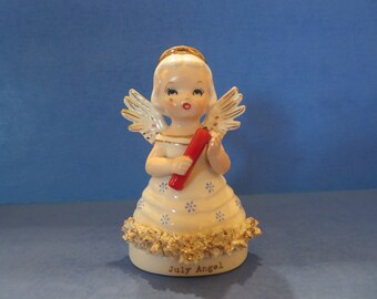 Wales July Angel Wears White Spaghetti Trimmed Dress Embellished with Blue Flowers - Holds a Firecracker!