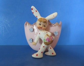 Lefton Easter Boy in Bunny Suit with Polka Dots Holding an Easter Egg Basket Standing in Front of a Pink Cracked Egg Wall Pocket