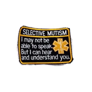 May include: Black and yellow embroidered patch with the text "SELECTIVE MUTISM I may not be able to speak. But I can hear and understand you." and a yellow medical symbol.