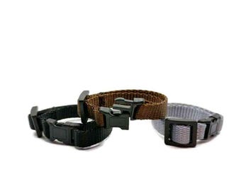 May include: Three adjustable dog collars in black, brown, and gray. Each collar has a plastic buckle.