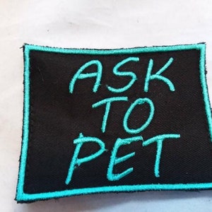 May include: Black fabric patch with a turquoise blue border and the text "ASK TO PET" embroidered in turquoise blue.