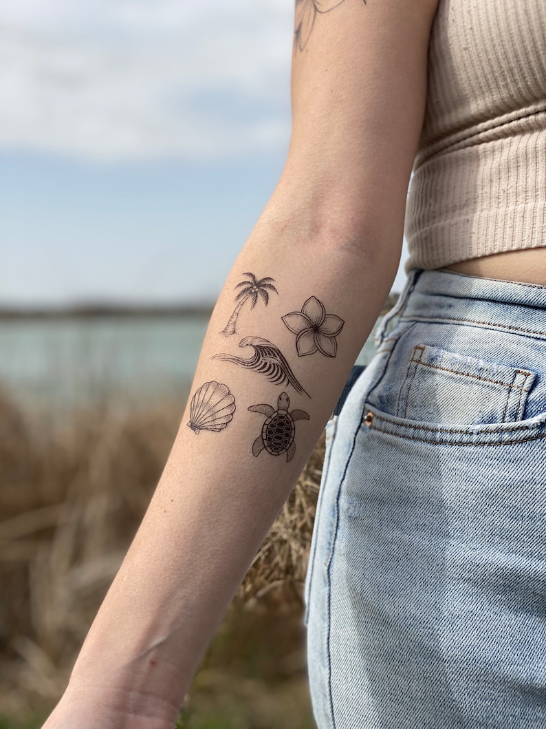 May include: A person's arm with four temporary tattoos: a palm tree, a flower, a seashell, and a turtle.
