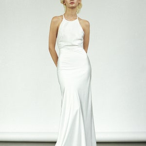 May include: A white halter-neck wedding dress with a fitted bodice and a flowing skirt.