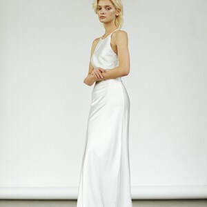 May include: A white halter-style wedding dress with a fitted bodice and a flowing skirt.