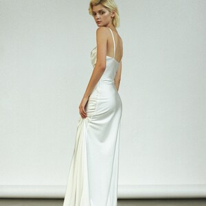 Peut inclure: Une robe blanche en satin avec un corsage ajust&eacute; et une jupe fluide. La robe a un design simple et &eacute;l&eacute;gant et est parfaite pour une occasion sp&eacute;ciale.