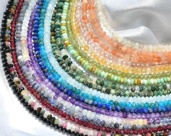 Könnte beinhalten: Eine Sammlung von Perlenketten in Regenbogenfarben, darunter Schwarz, Rot, Lila, Blau, Grün, Gelb und Orange. Jede Halskette besteht aus kleinen, runden Perlen. Die Halsketten sind halbkreisförmig auf einer weißen Oberfläche angeordnet.