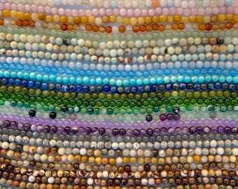 Könnte beinhalten: Sortiment an bunten Edelsteinperlen, angeordnet in Reihen. Jede Reihe zeigt eine andere Art von Perle, darunter blaue, grüne, violette und braune.