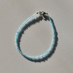 May include: A light blue beaded bracelet with a silver clasp.