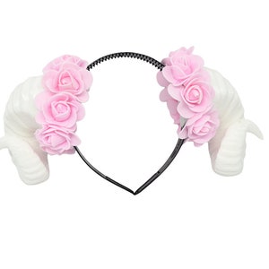 Peut inclure: Un serre-tête blanc avec deux cornes blanches et des fleurs en tissu rose de chaque côté.
