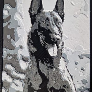 Puede incluir: Retrato en relieve en blanco y negro de un perro pastor alemán. El perro está representado con la lengua fuera, sobre un fondo texturizado de diferentes tonos de gris y blanco, enmarcado en negro.